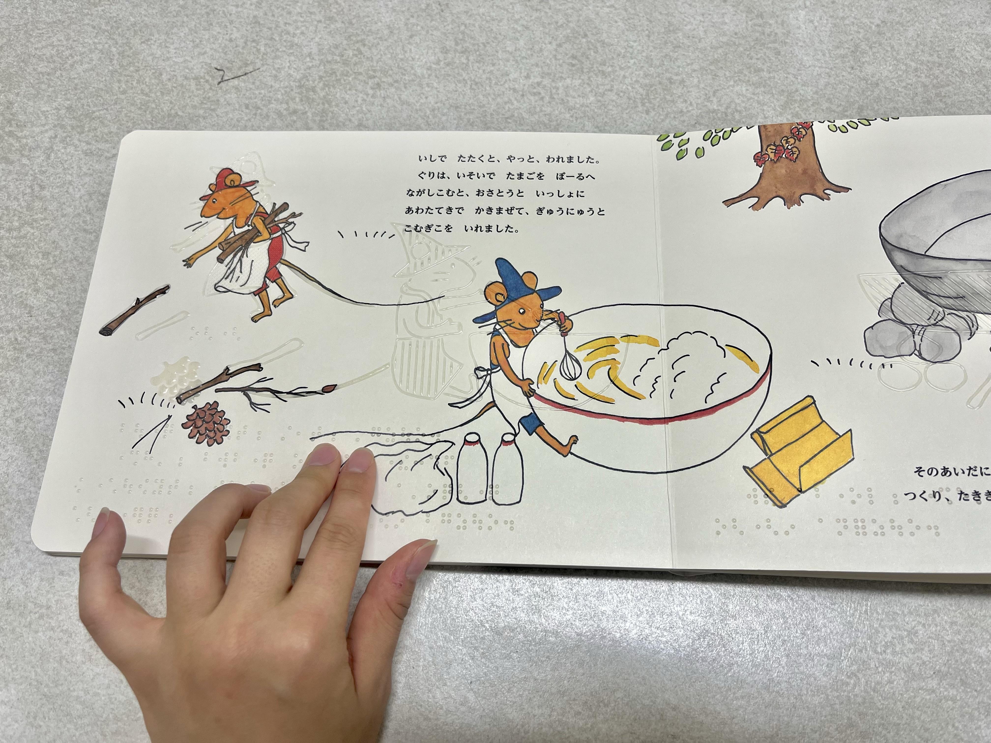 「ぐりとぐら ( てんじつきさわるえほん )」を読んでいる様子を写した画像.jpg